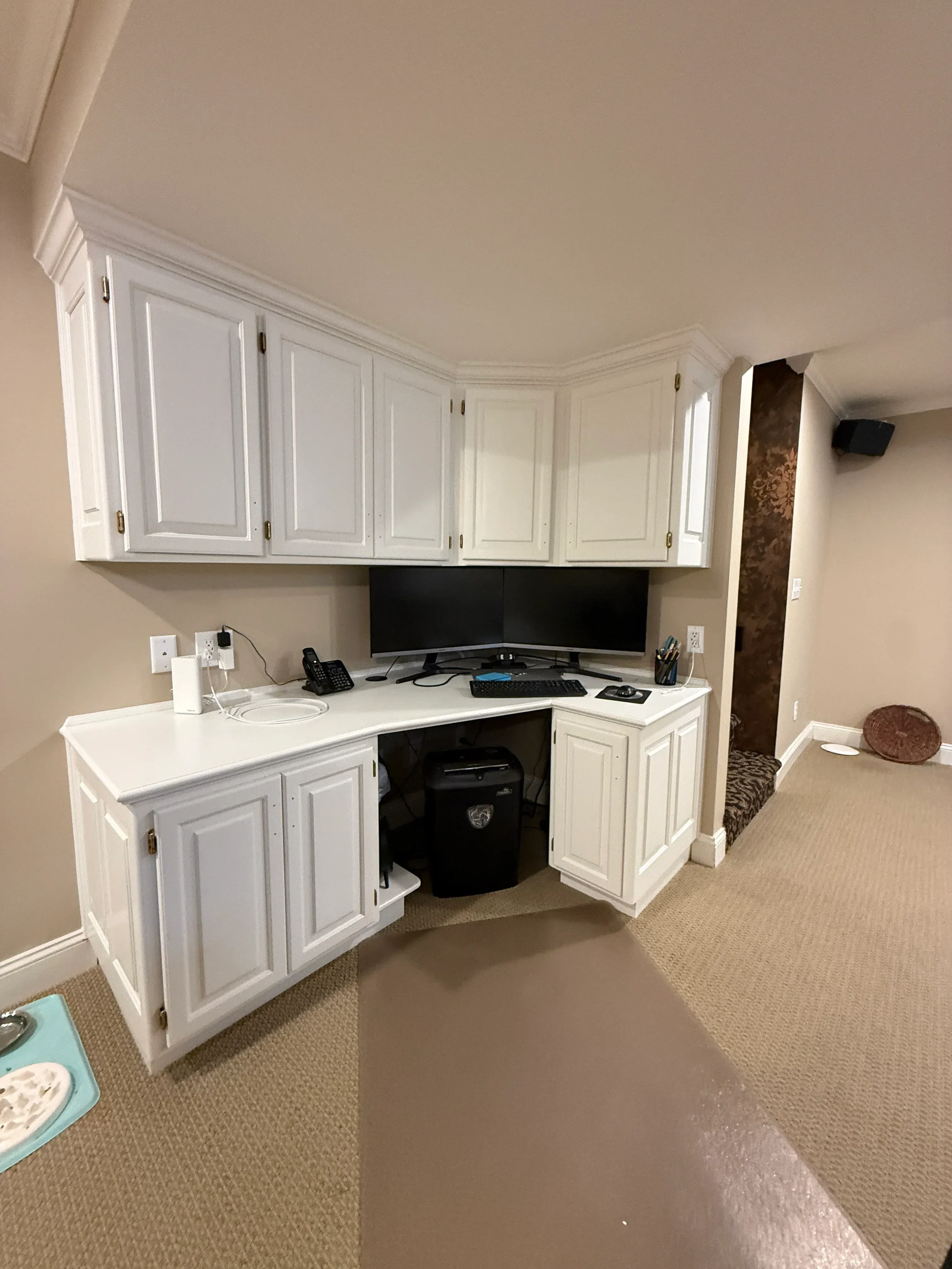 White painted built-in cabinetry with raised-panel doors and brass hardware in bedroom nook
